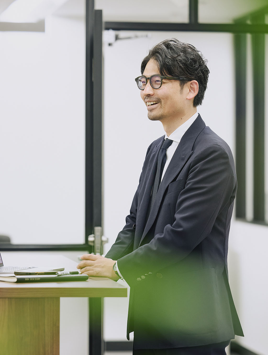 代表社員 八木義昭がオフィスで微笑む写真